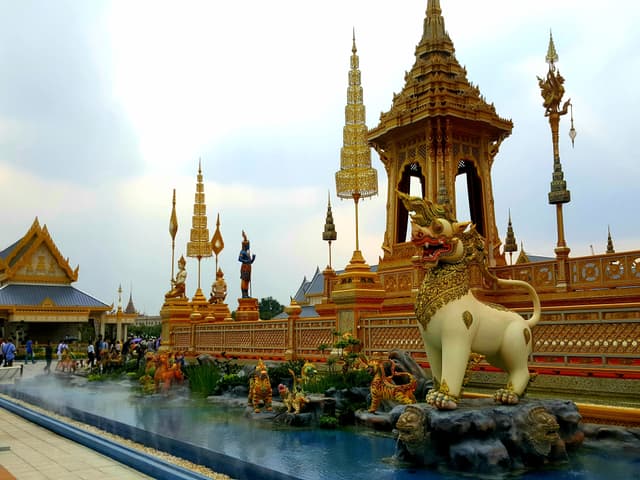 One of the square's most photogenic corners for group portraits, with the Grand Palace roofs behind. — Sanam Luang, Bangkok, Thailand