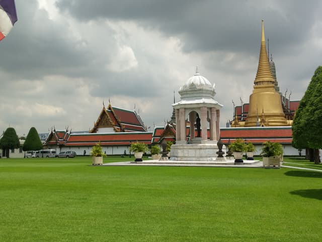 Standing water after rain reflects the lawn and walkways, adding depth to a photo. — Sanam Luang, Bangkok, Thailand